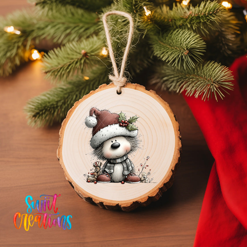 A wooden ornament featuring a cartoon character wearing a Santa hat and scarf, hanging on a Christmas tree.