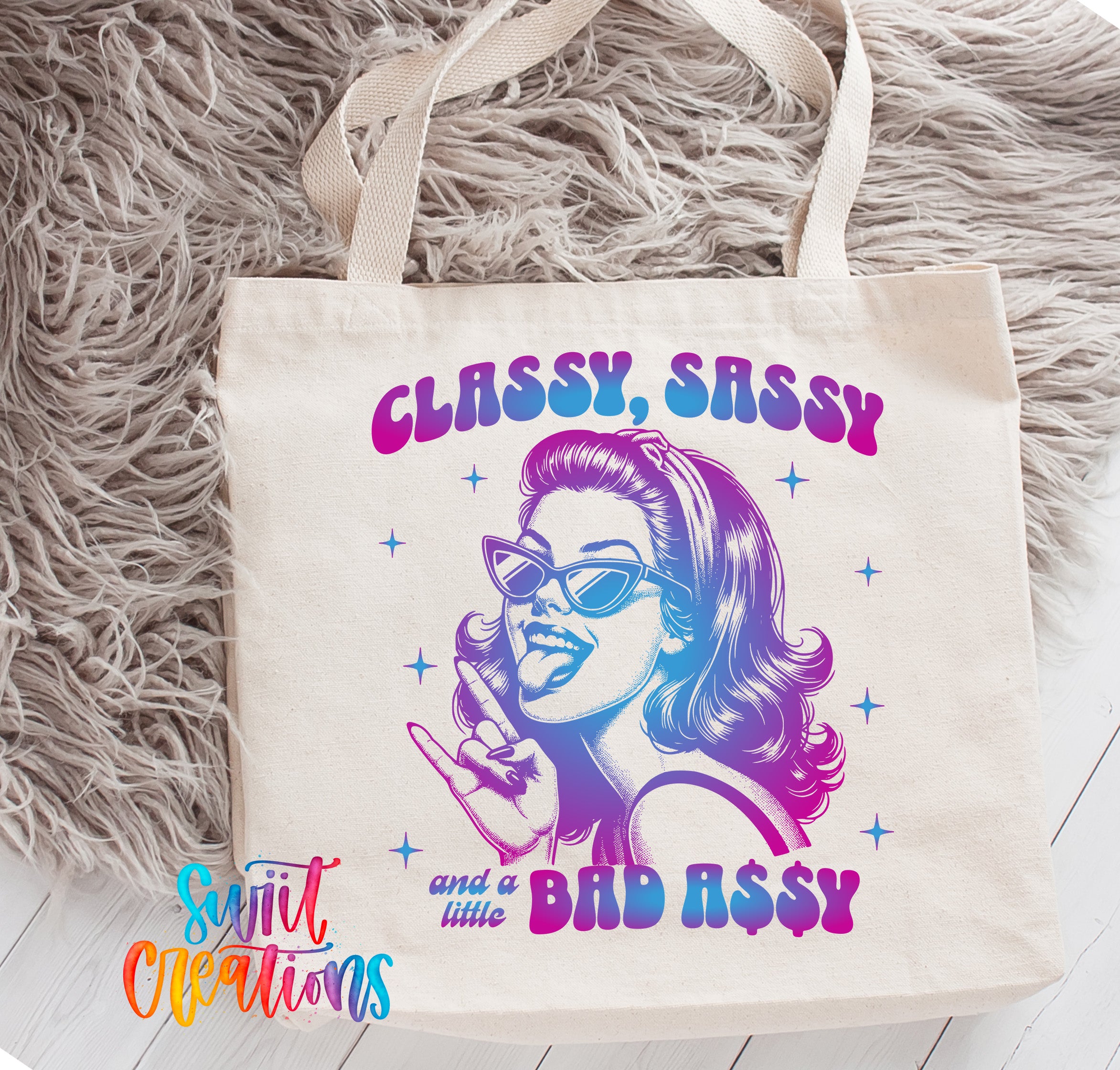 A white tote bag with a colorful graphic design featuring a woman's face wearing sunglasses and a playful expression.