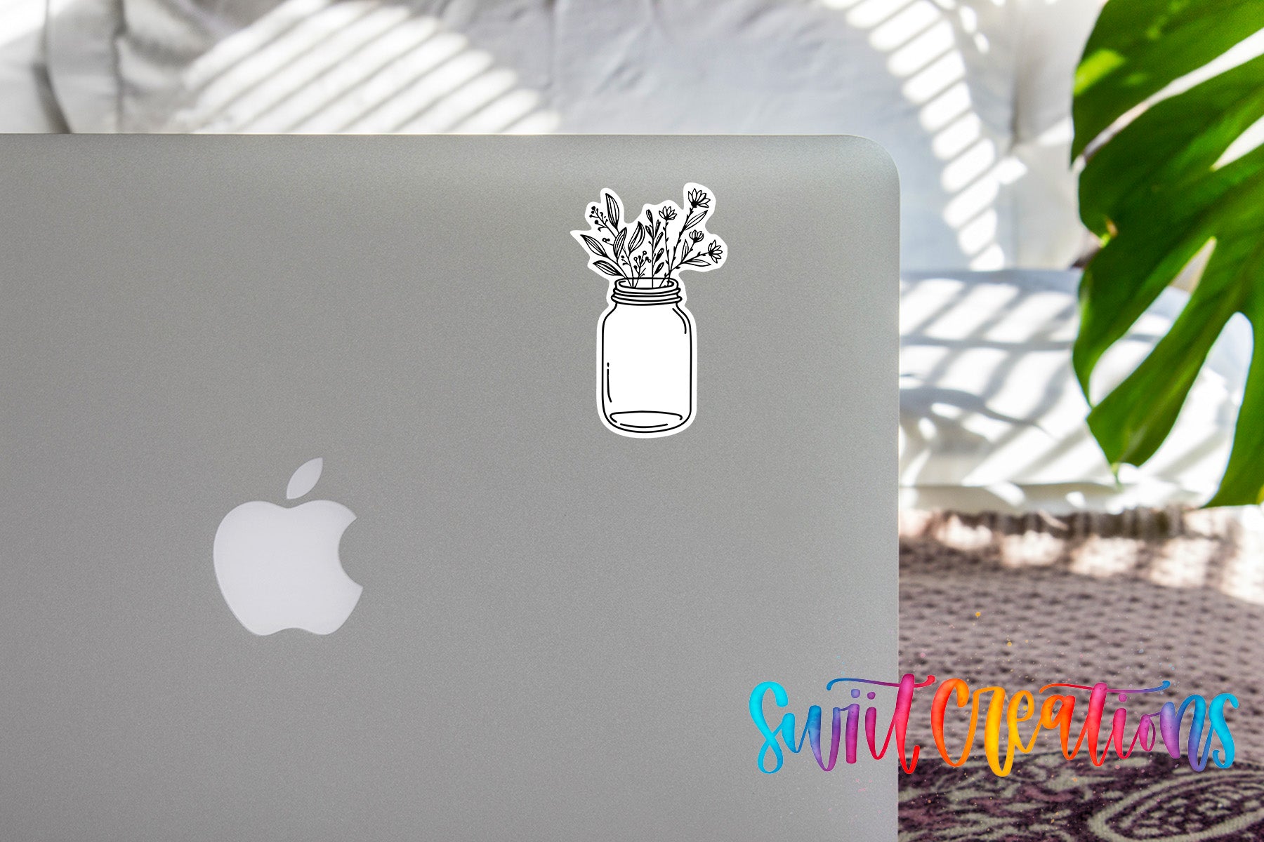 a sticker of a jar with flowers on a laptop, and there is a colorful text overlay in the bottom right corner that reads "SwiftCreators".