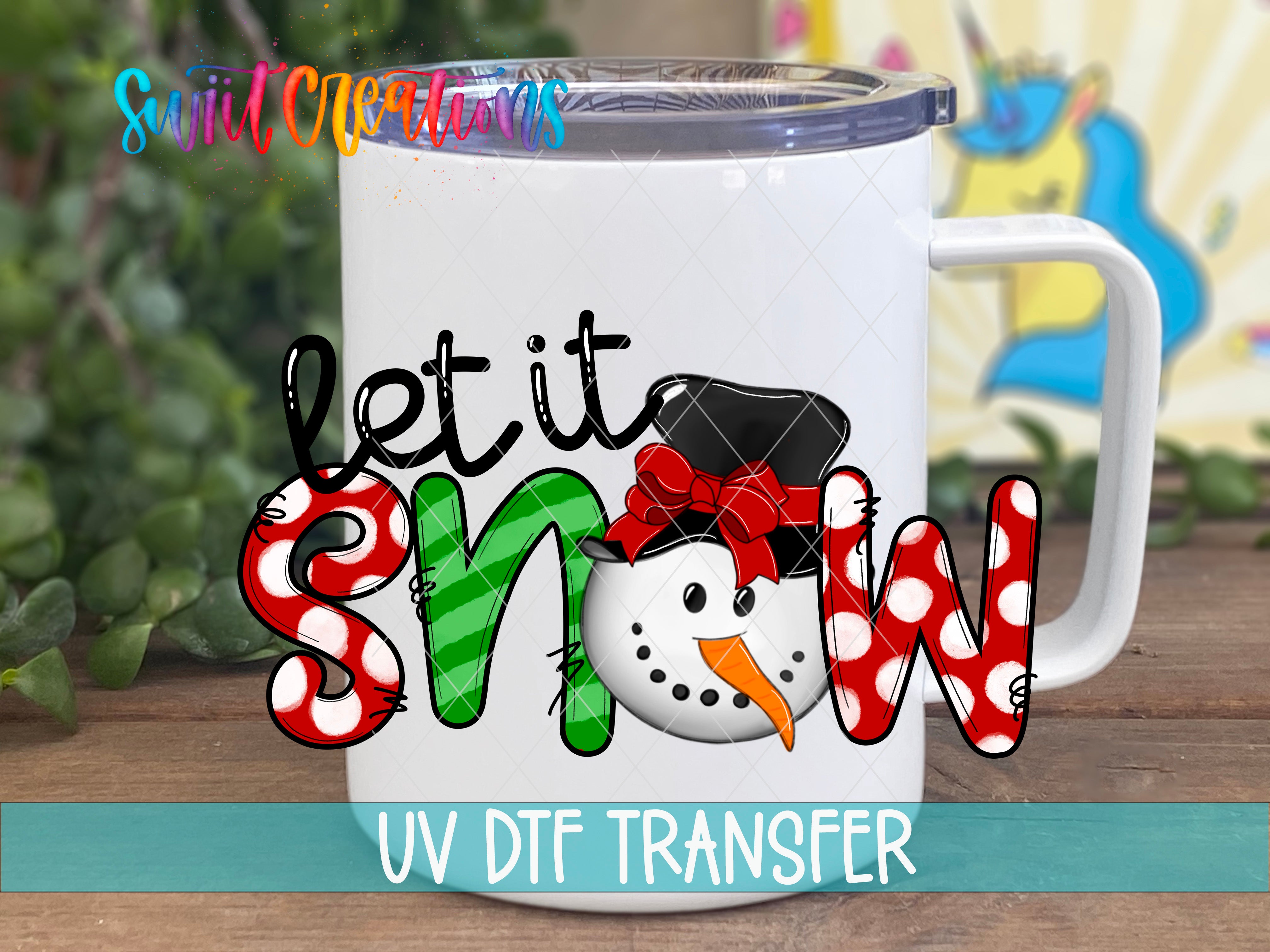A white mug with a snowman design and the text "let it snow" printed on it.