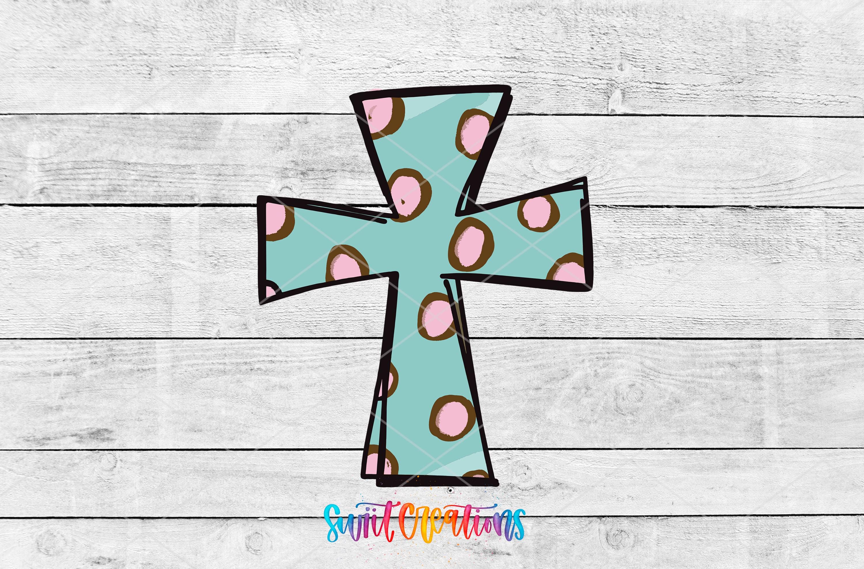 A colorful, abstract cross-shaped design with a polka dot pattern in shades of blue and pink against a white wooden background.
