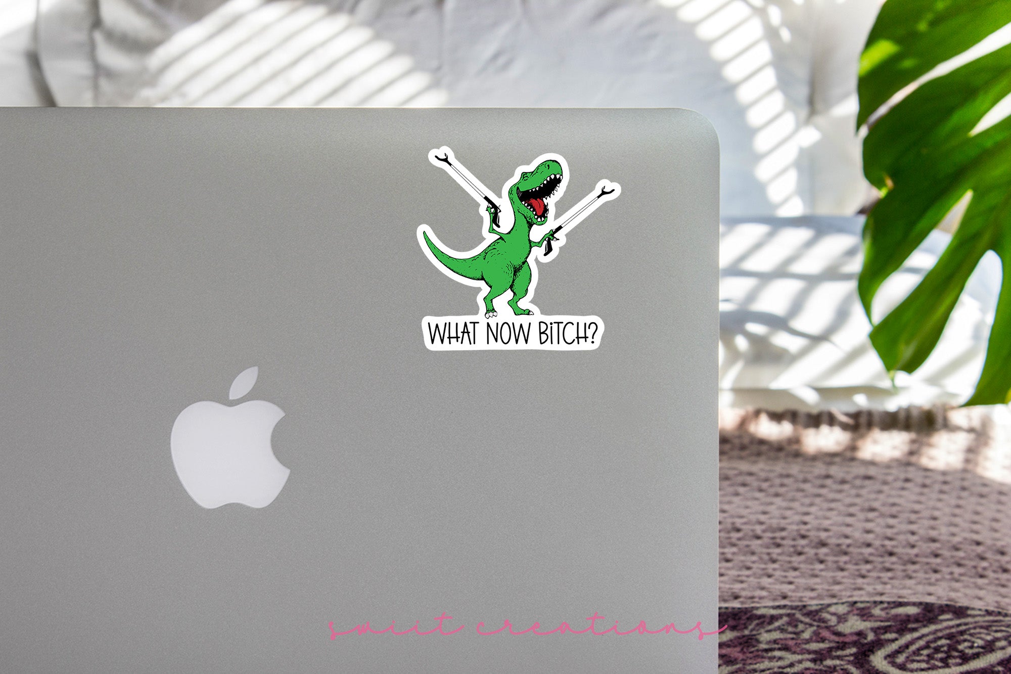 a laptop with a sticker of a dinosaur on it
