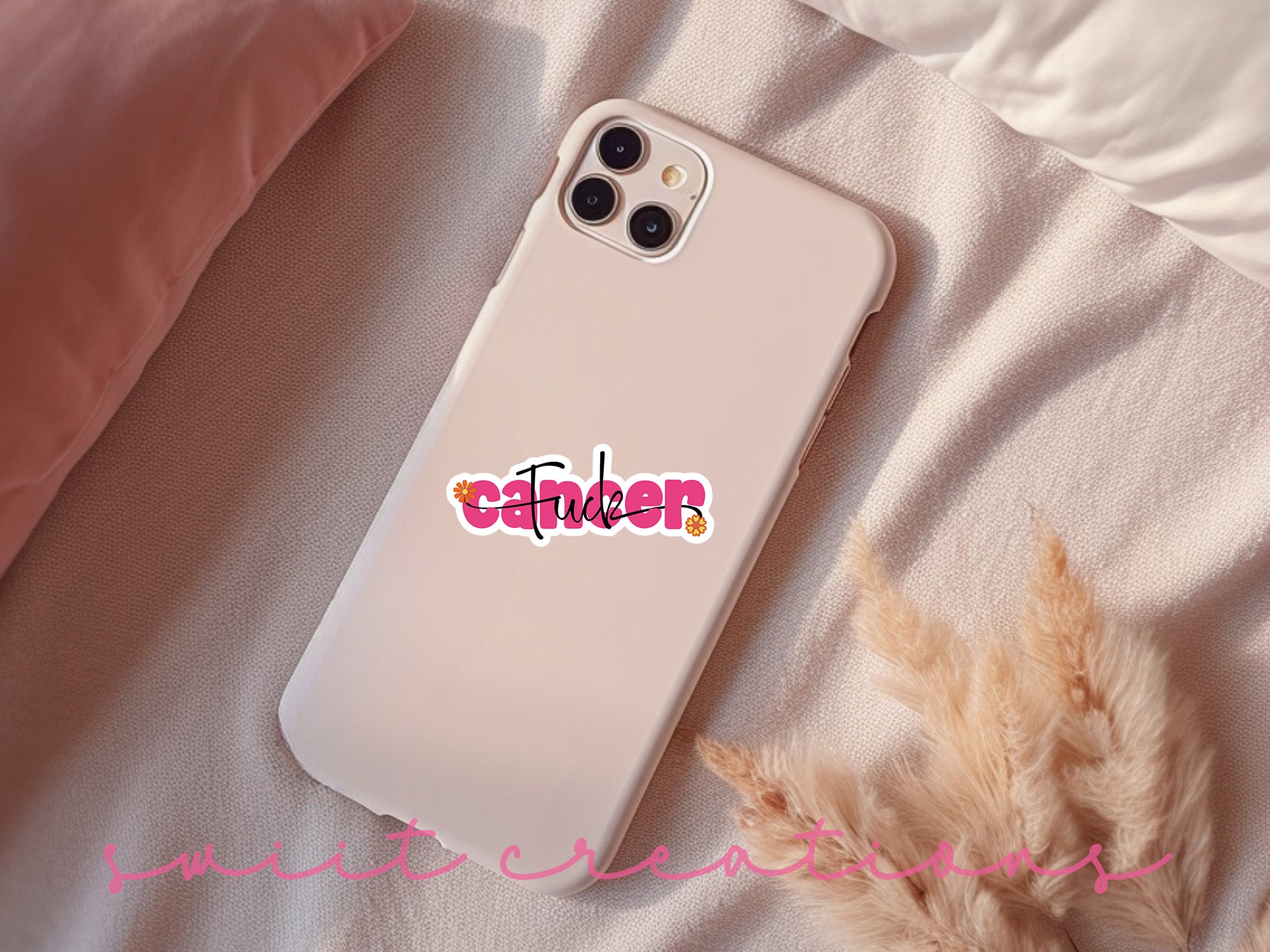 a phone case with a sticker on it sitting on a bed