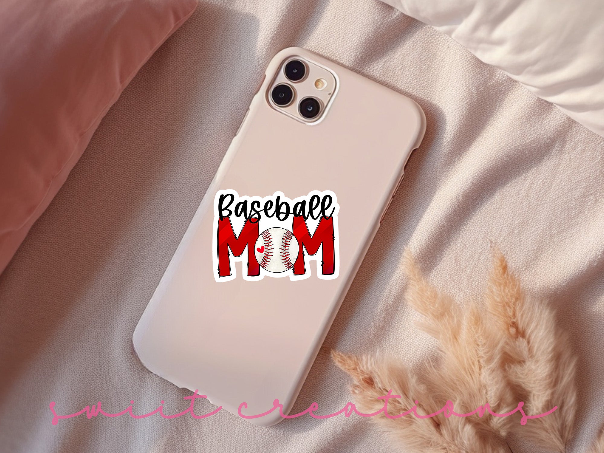 a baseball mom phone case sitting on top of a bed