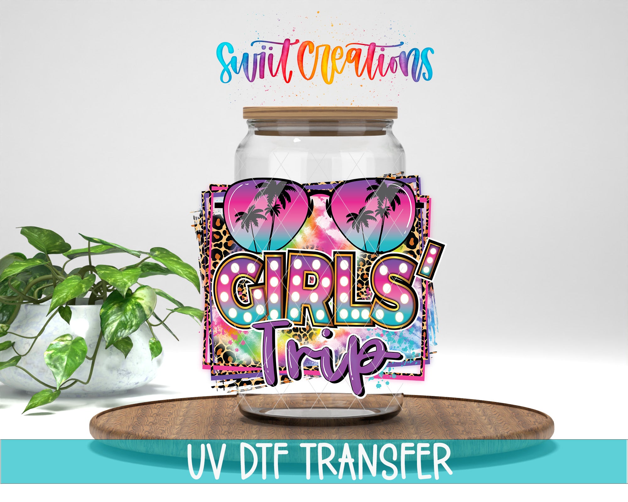 a large glass jar with a colorful, tropical-themed design, including palm trees and a heart shape, along with the text "GIRLS TRIP" printed on it. The jar is placed on a wooden surface, and there is a potted plant in the background.