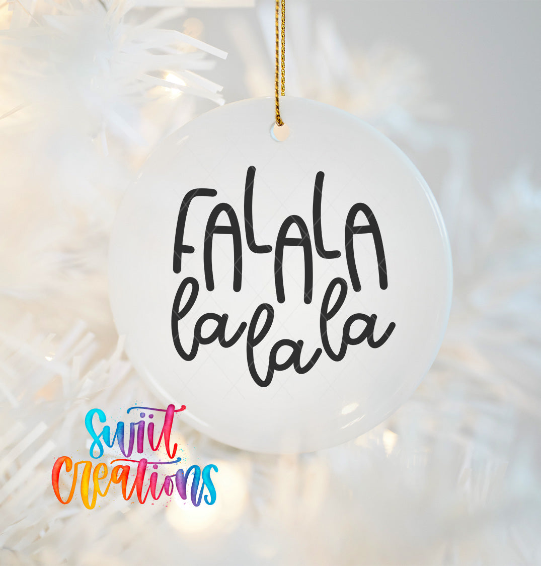 A white ornament with the text "FALA la la la" written on it, hanging on a string.