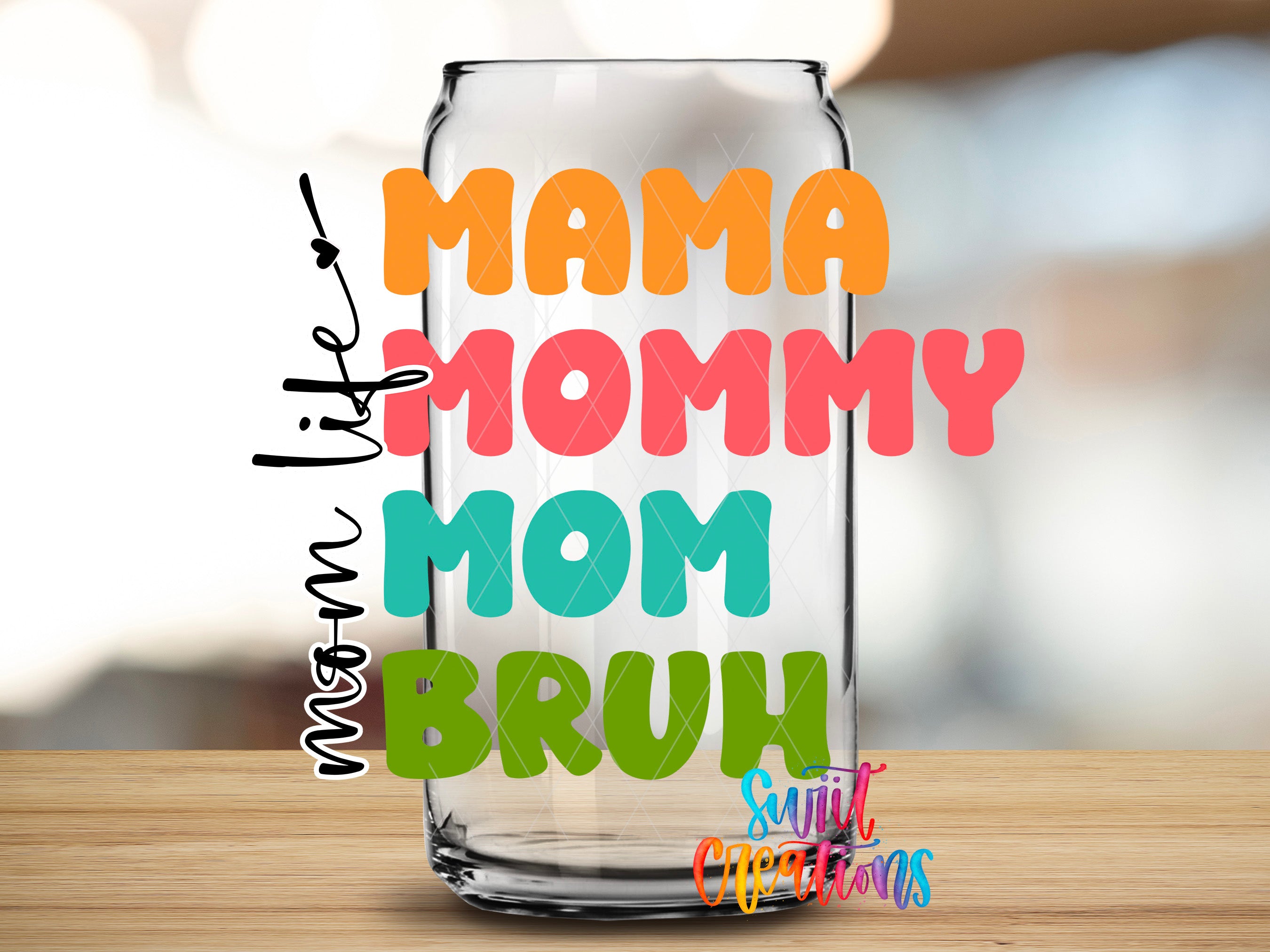 A glass can with colorful text on it, placed on a wooden surface.