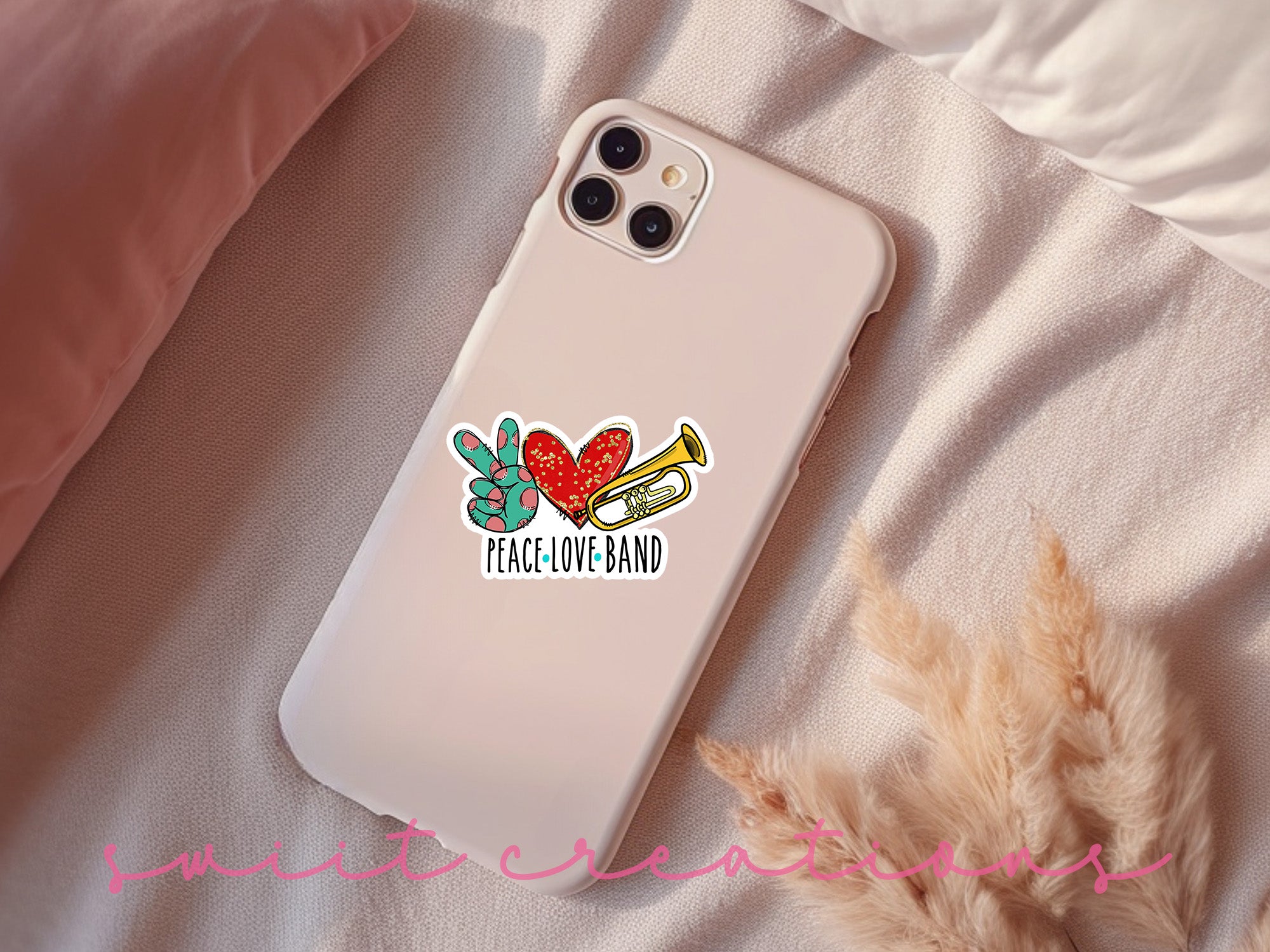 a phone case with a sticker on it sitting on a bed