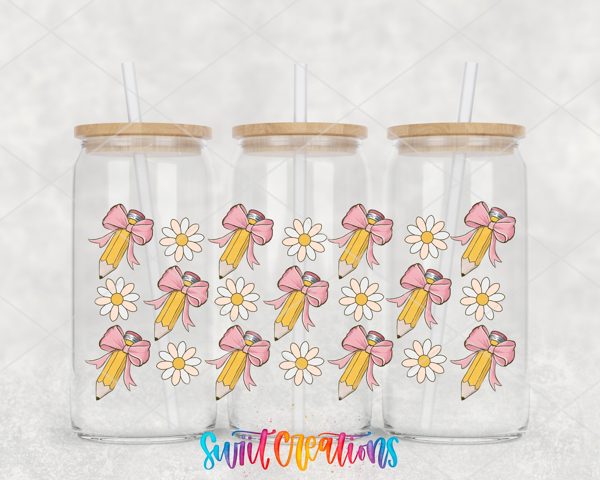 Three clear glass tumblers with wooden lids, each decorated with a pattern of pink bows and white daisies on a yellow pencil.