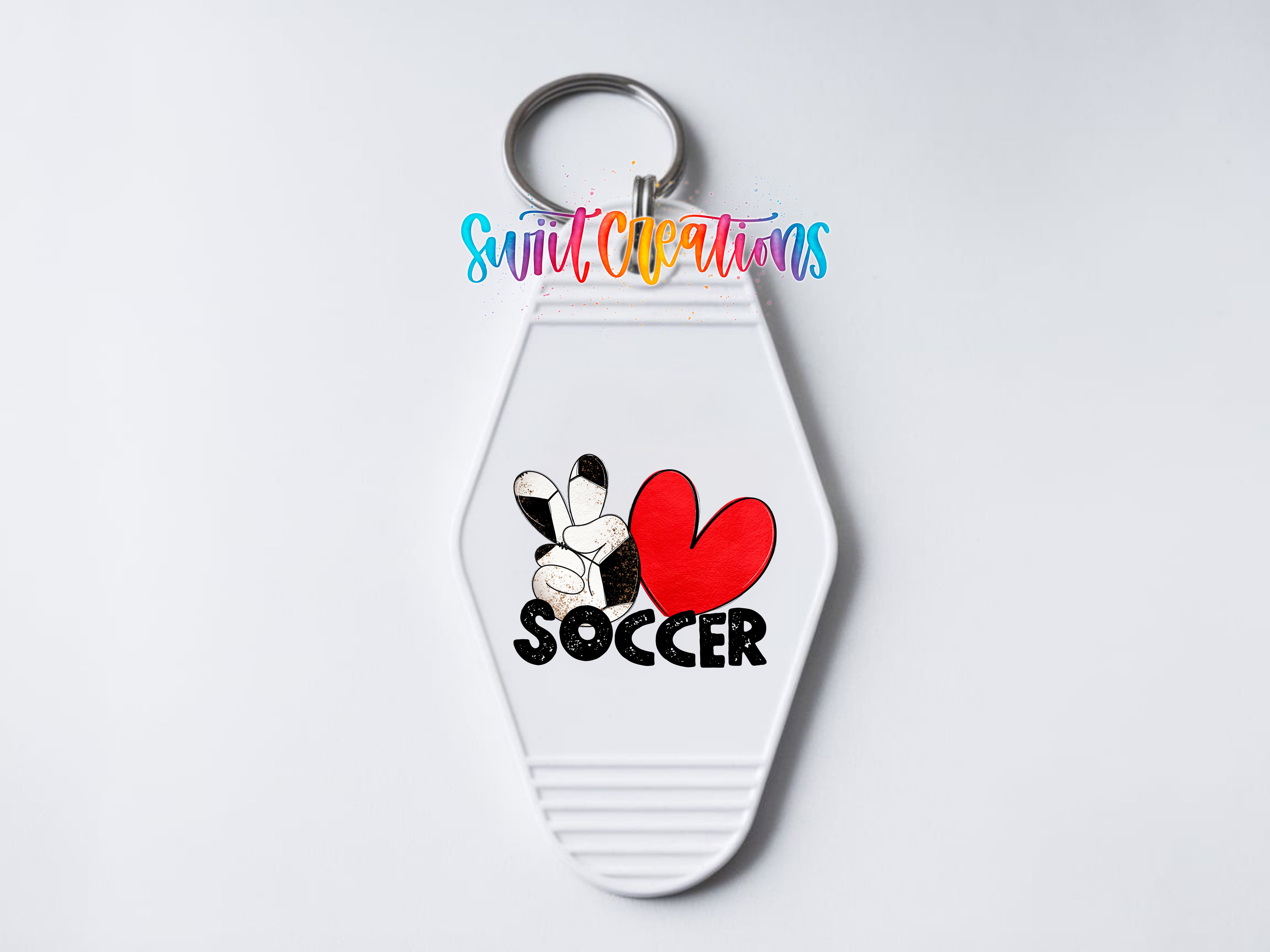 A white keychain with a soccer-themed design, including a red heart and the word "SOCCER".