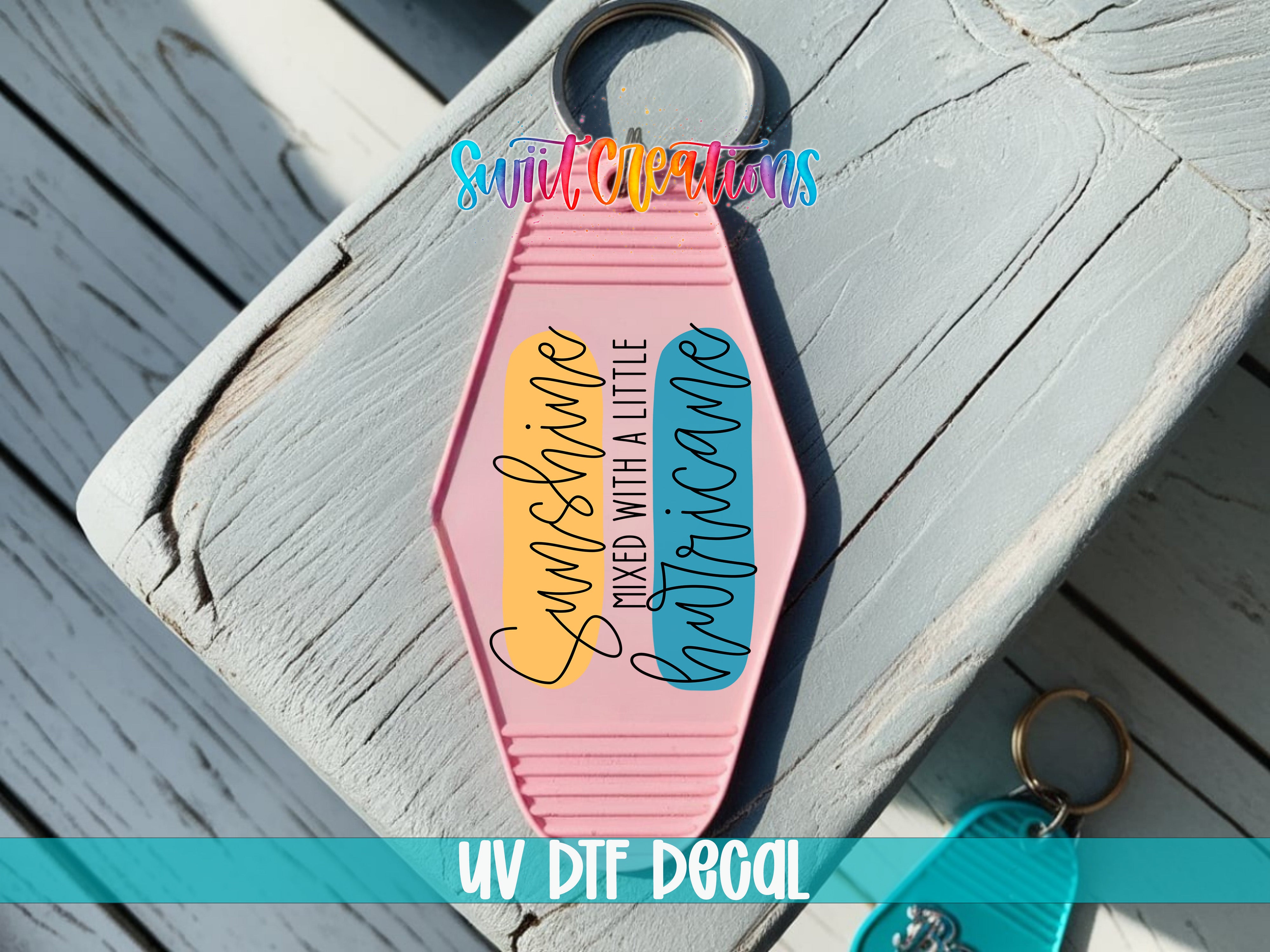 A keychain with a pink and yellow design, featuring the text "Sunshine mixed with a little Hurricane" printed on it.