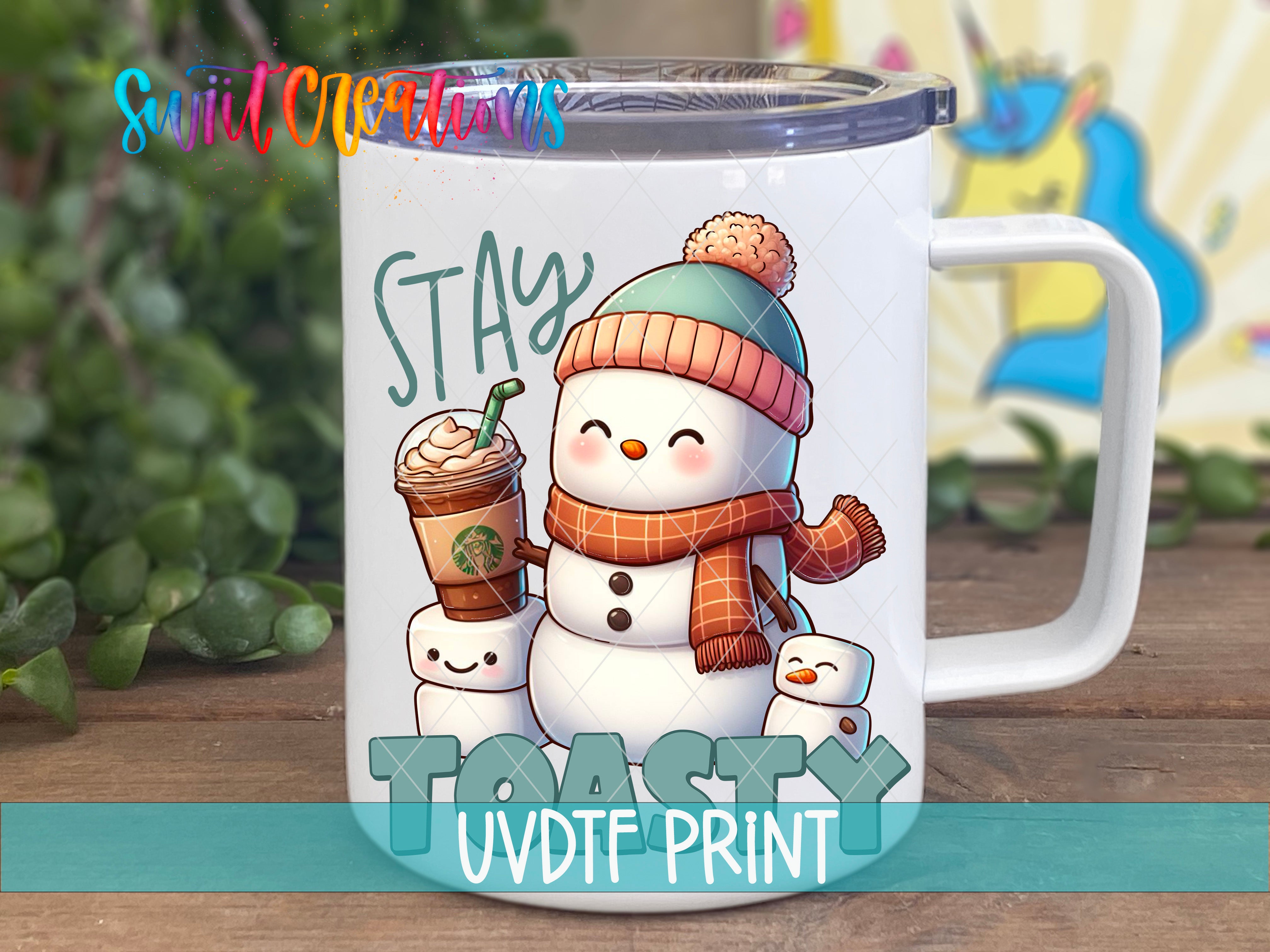 A white mug with a snowman and marshmallow design, along with the text "STAY TOASTY UVDIF PRINT".