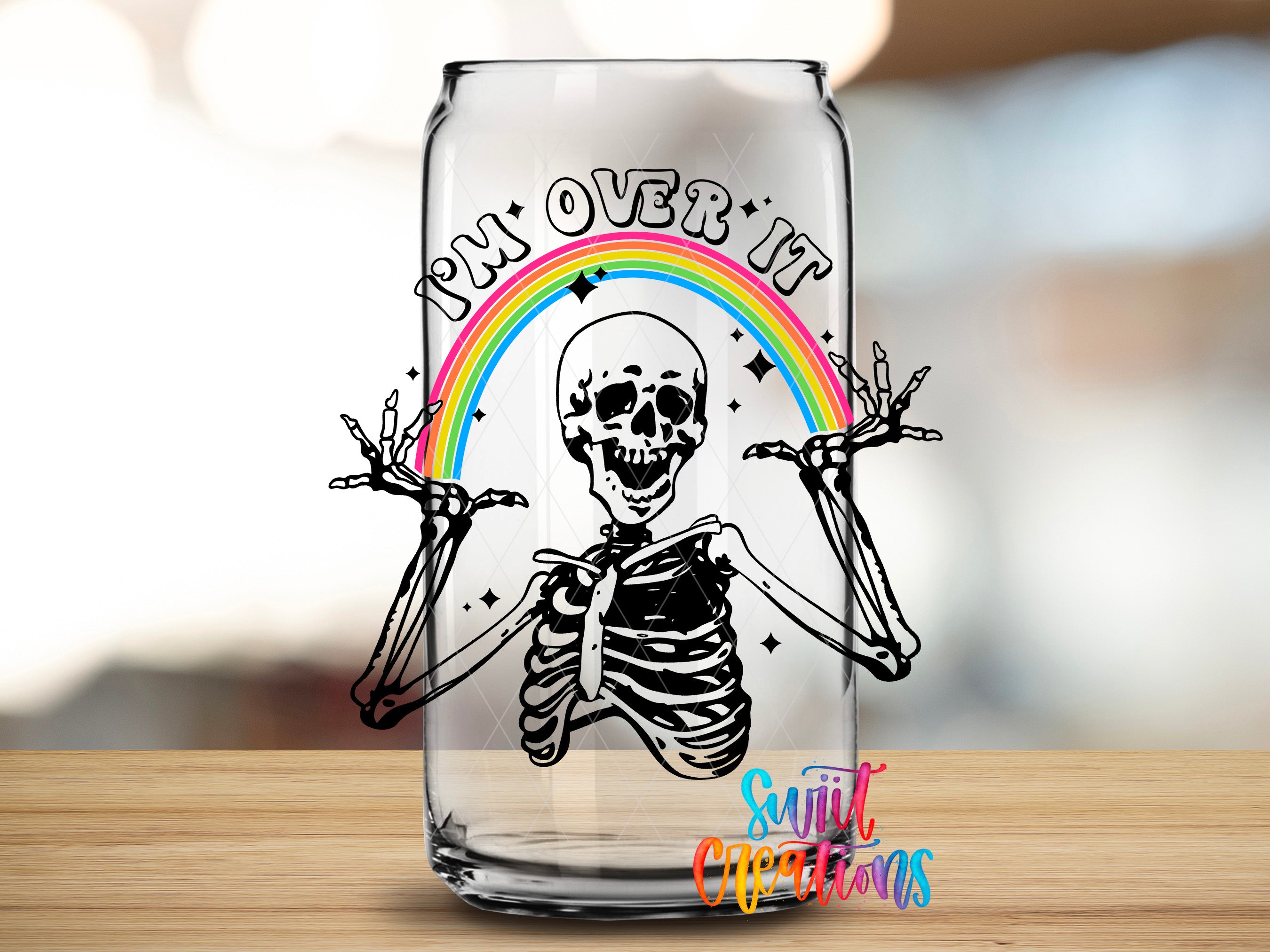 A glass can with a skeleton and a rainbow graphic on it, along with the text "I'm over it" written above the skeleton.