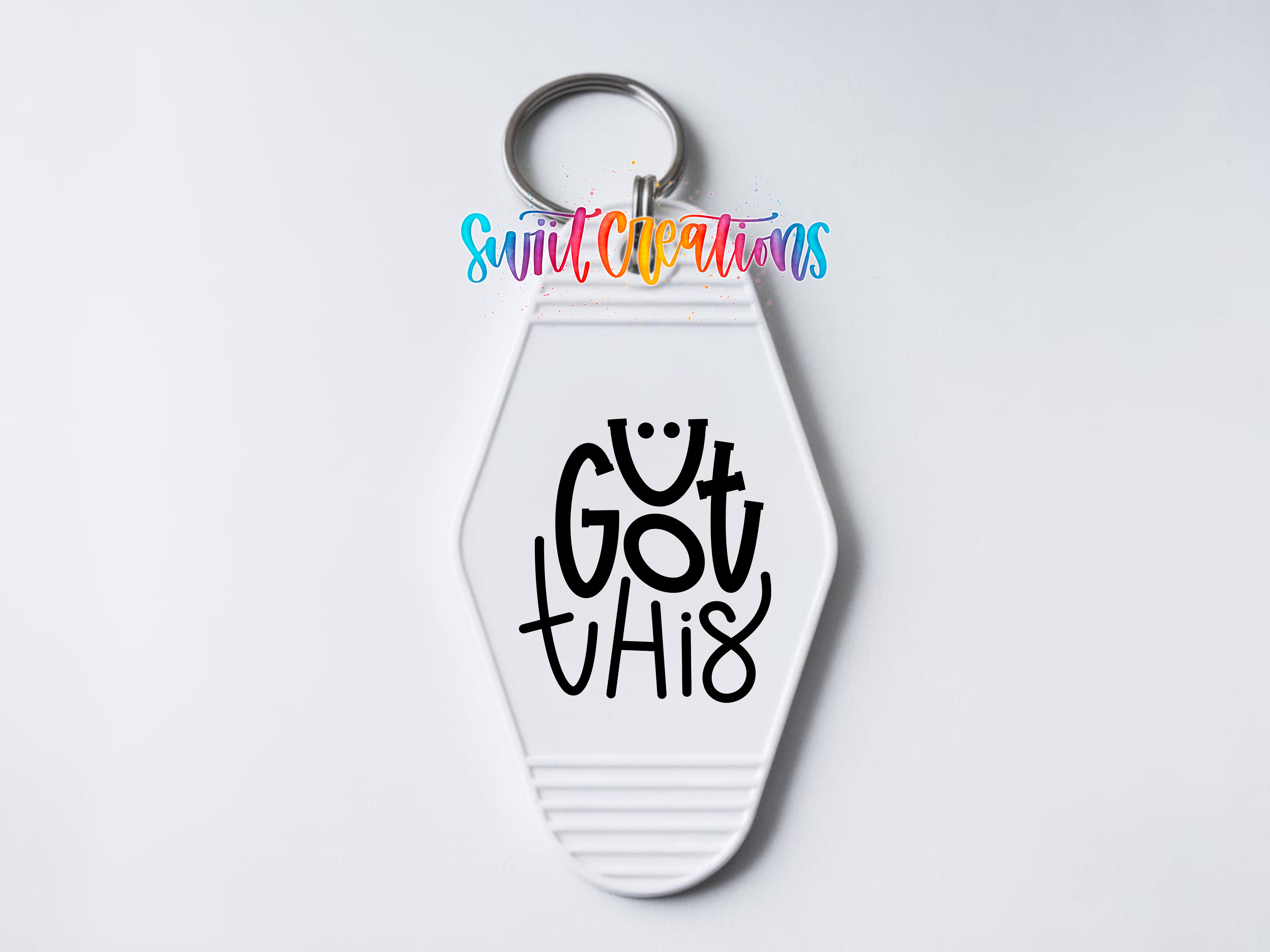 A white keychain with a motivational message printed on it.