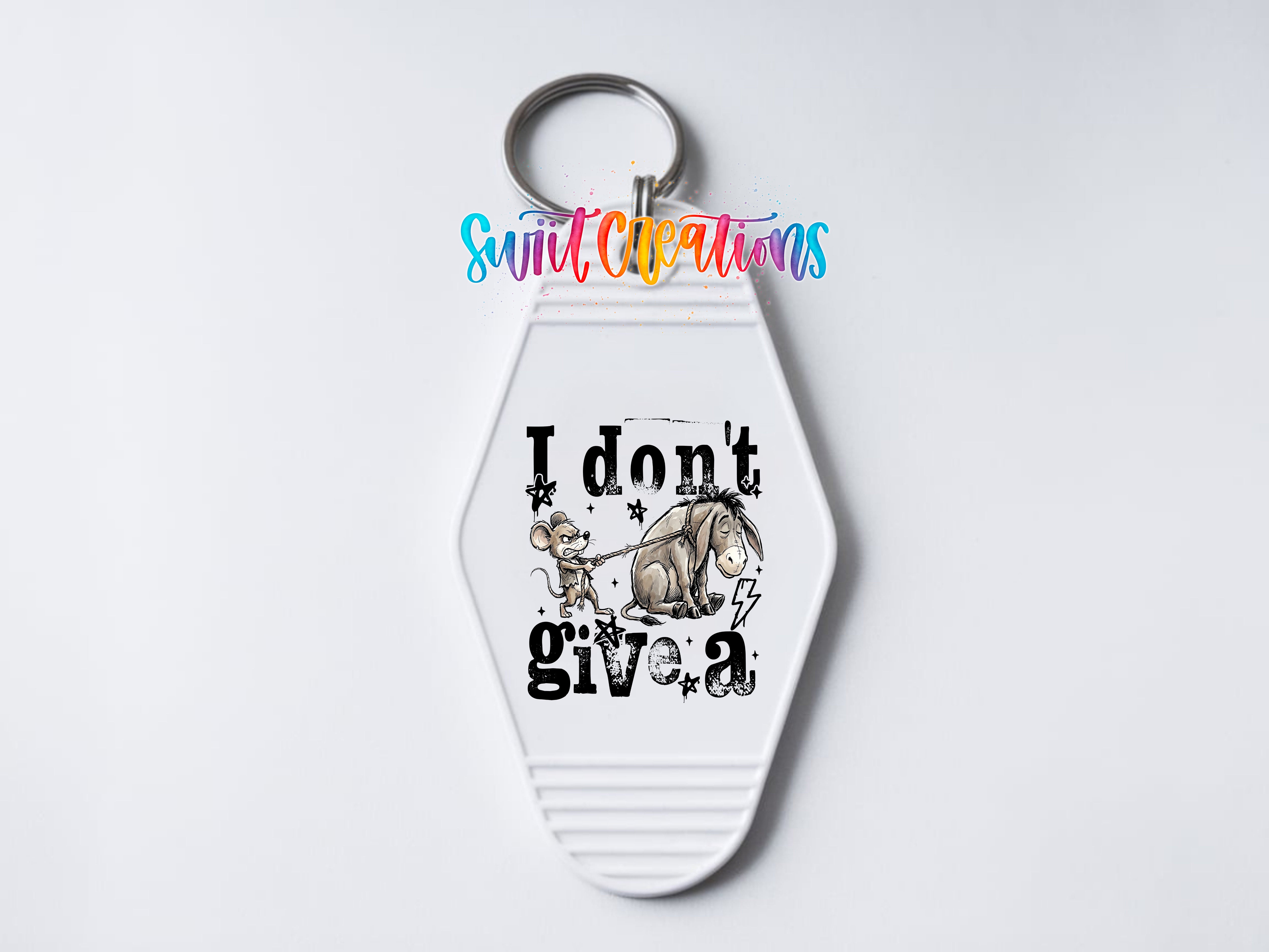 A keychain with a cartoon image of Eeyore and the text "I don't give a" printed on it.