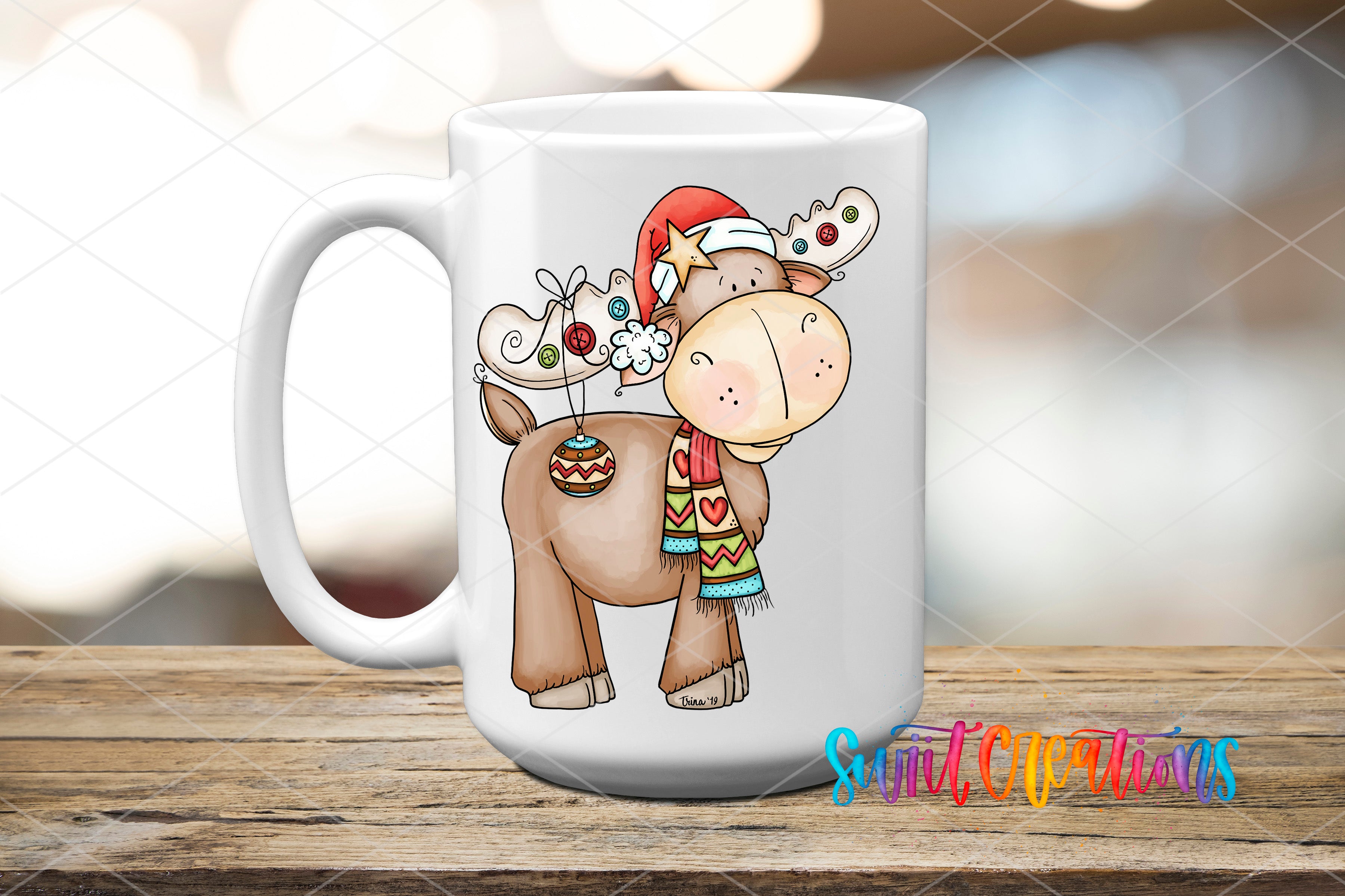 A white ceramic mug with a cartoon illustration of a moose wearing a Santa hat and scarf, sitting on a wooden surface.