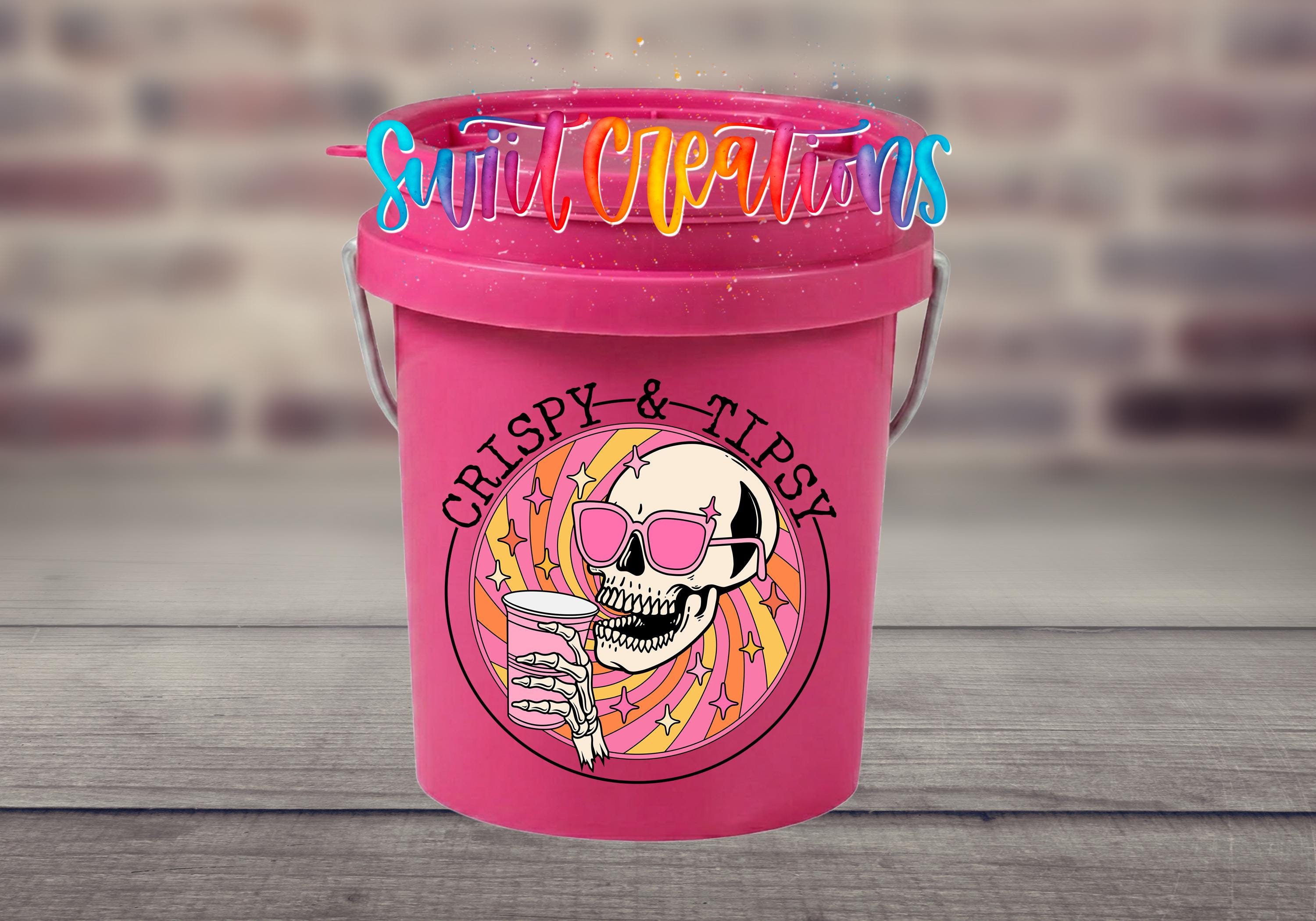 A pink bucket with a skull wearing sunglasses and holding a drink, surrounded by colorful text and graphics.