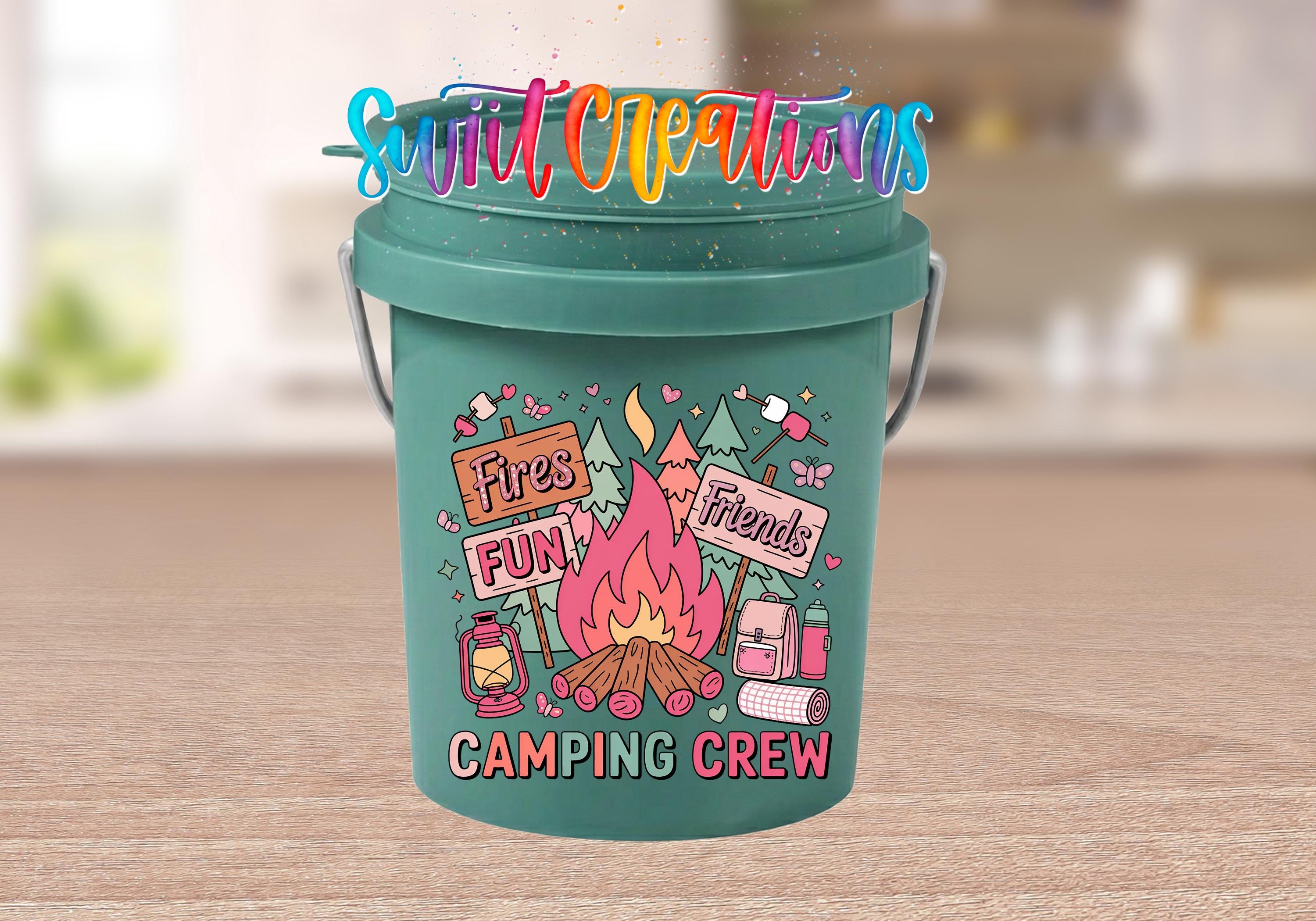 A green bucket with a colorful design featuring camping-related items and text, including a campfire, lantern, and camping equipment.