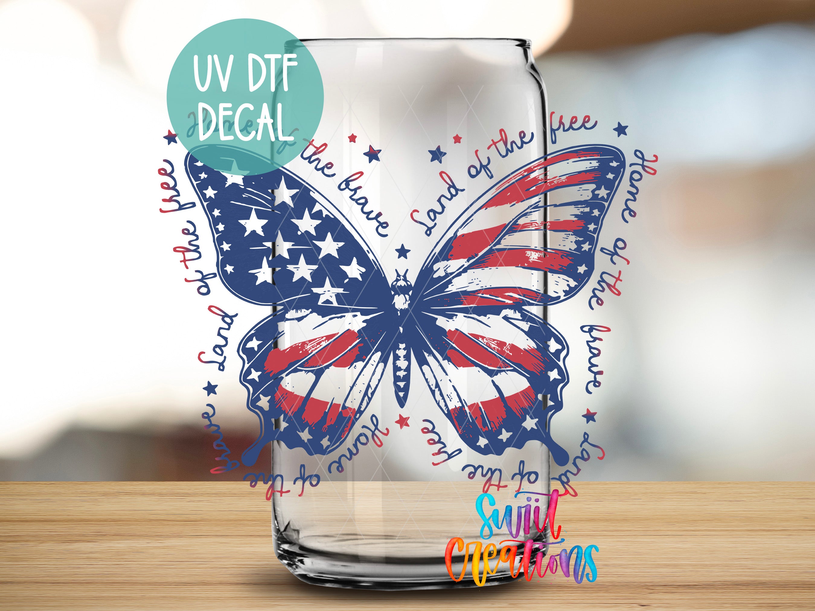 a glass with a butterfly design and the words "Land of the free" written around it.