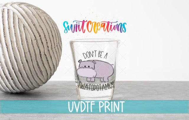 a glass with a cartoon hippo and the text "Don't be a water pootamus" printed on it, along with a colorful text logo that says "Swift Creations" and "UVDF PRINT".