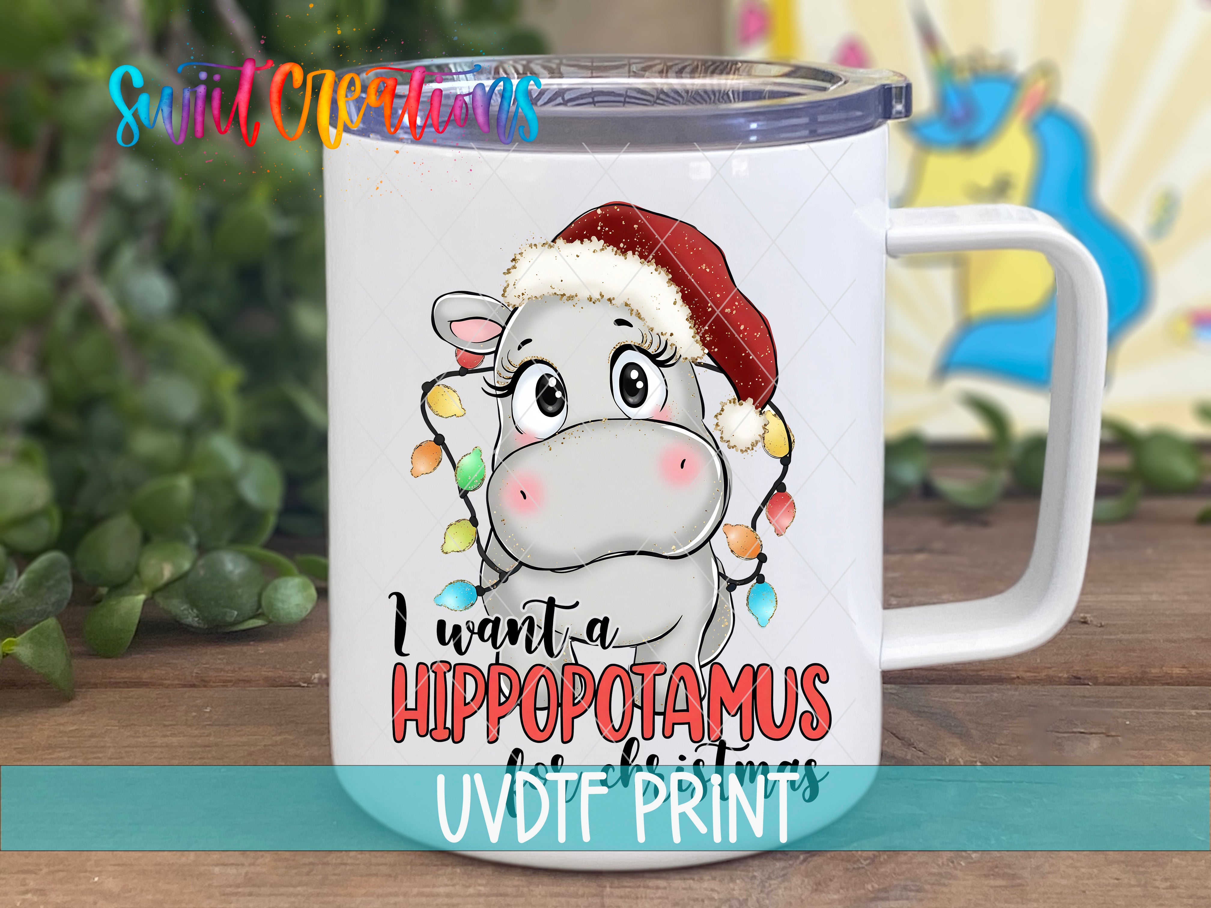 A white mug with a cartoon image of a hippopotamus wearing a Santa hat and the text "I want a Hippopotamus for Christmas" printed on it.