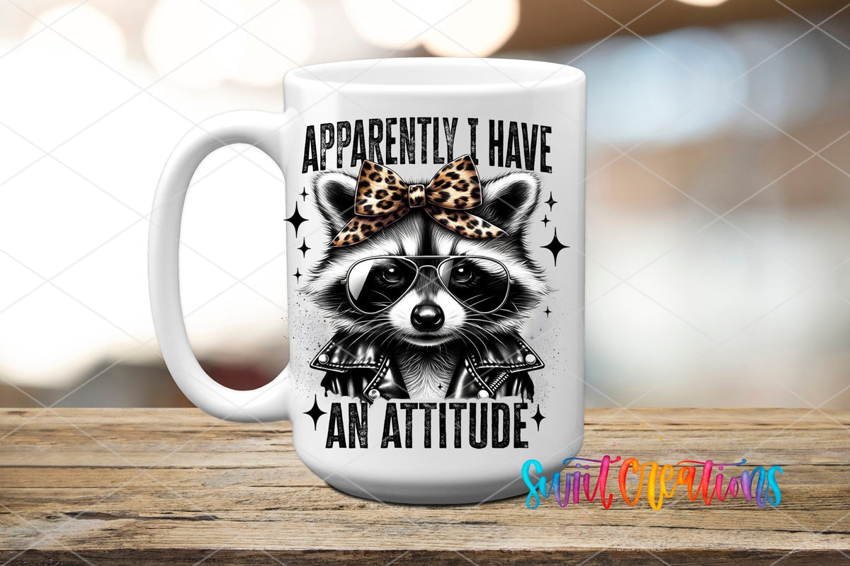 Funny Raccoon Apparently I Have An Attitude UV DTF transfer displayed on a white ceramic mug from Swiit Creations