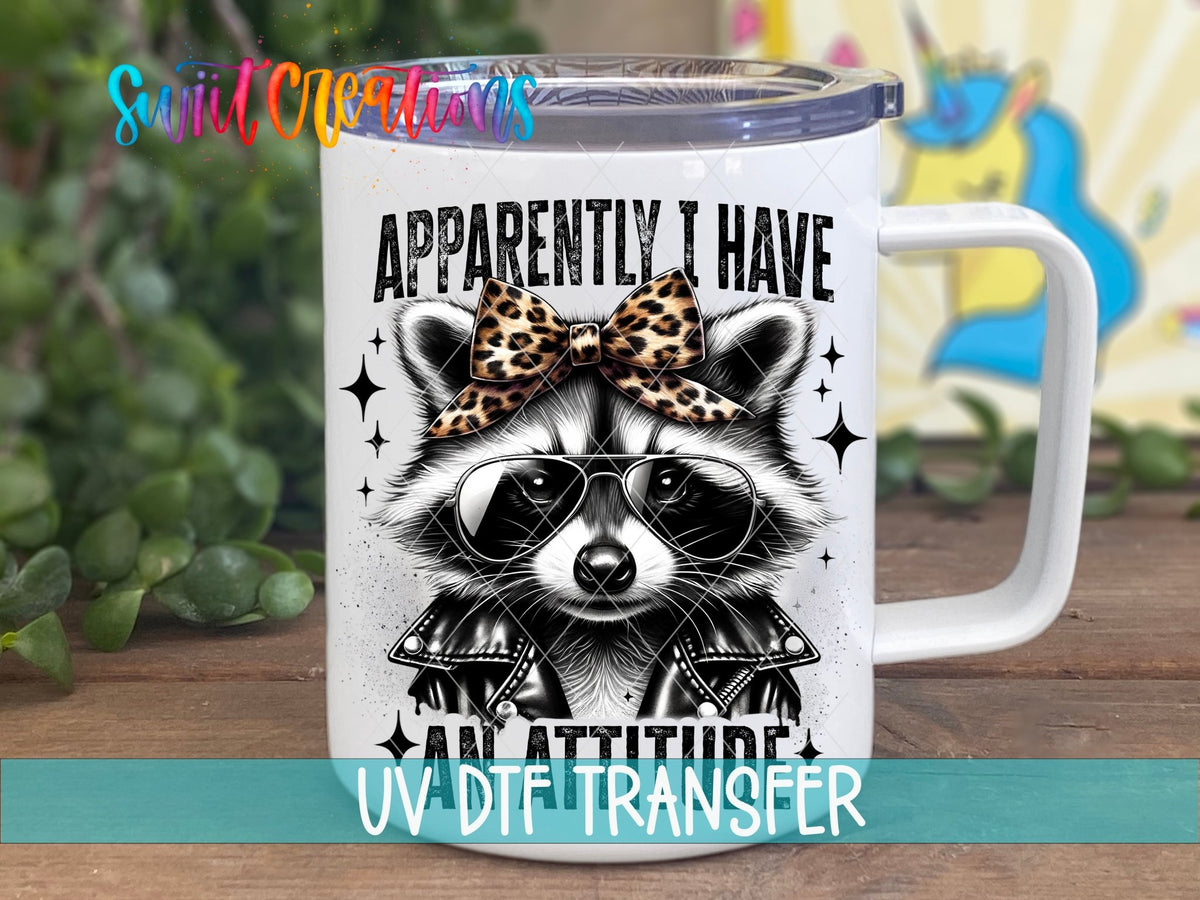 Funny Raccoon Apparently I Have An Attitude UV DTF transfer displayed on a white coffee mug from Swiit Creations