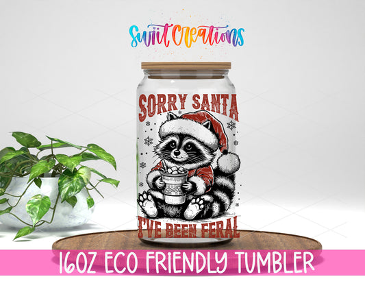 Sorry Santa Feral Raccoon design on a 16 oz clear glass tumbler with bamboo lid