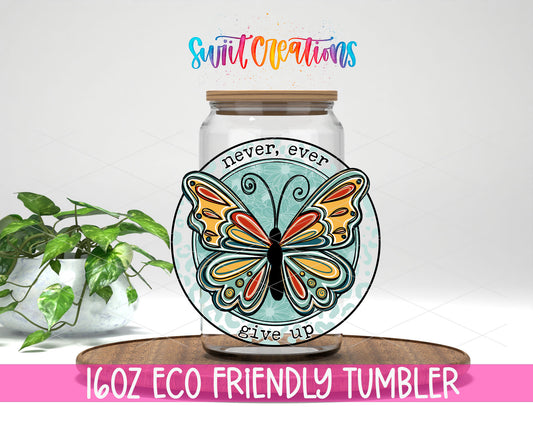 Never Ever Give Up Butterfly design on a 16 oz clear glass tumbler with bamboo lid