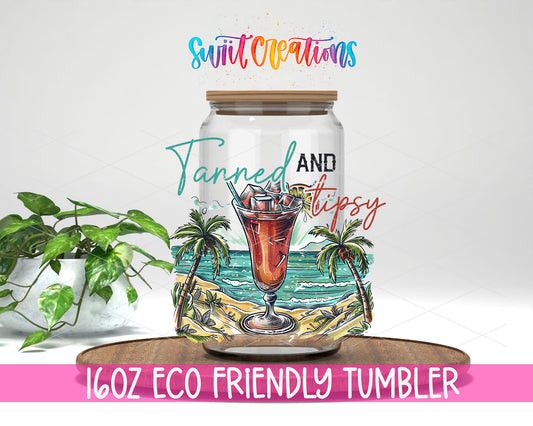 Tanned and Tipsy Tropical design on a 16 oz clear glass tumbler with bamboo lid