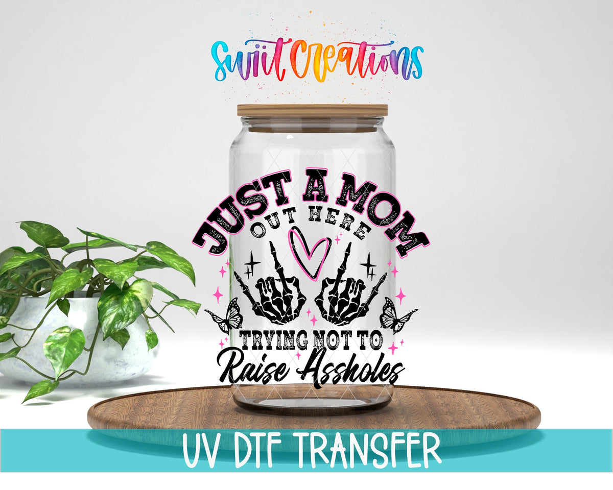 Just a Mom Trying Not To Raise Assholes UV DTF transfer displayed on a clear jar mockup from Swiit Creations