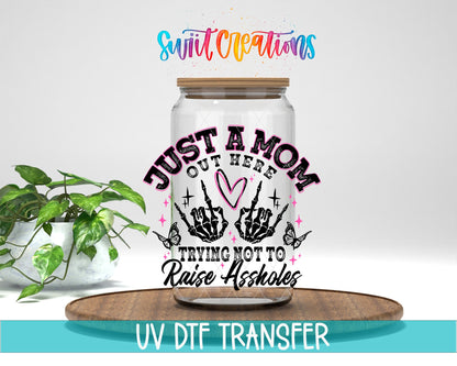 Just a Mom Trying Not To Raise Assholes UV DTF transfer displayed on a clear jar mockup from Swiit Creations