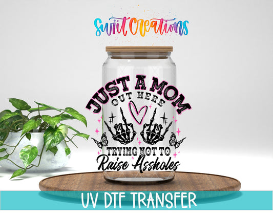 Just a Mom Trying Not To Raise Assholes UV DTF transfer displayed on a clear jar mockup from Swiit Creations