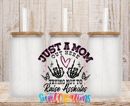 Just a Mom Trying Not To Raise Assholes UV DTF transfer applied to a clear glass can set from Swiit Creations