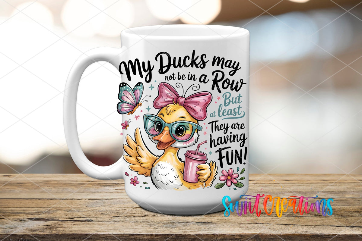 My Ducks May Not Be In A Row Funny Duck UV DTF transfer displayed on a white ceramic mug from Swiit Creations