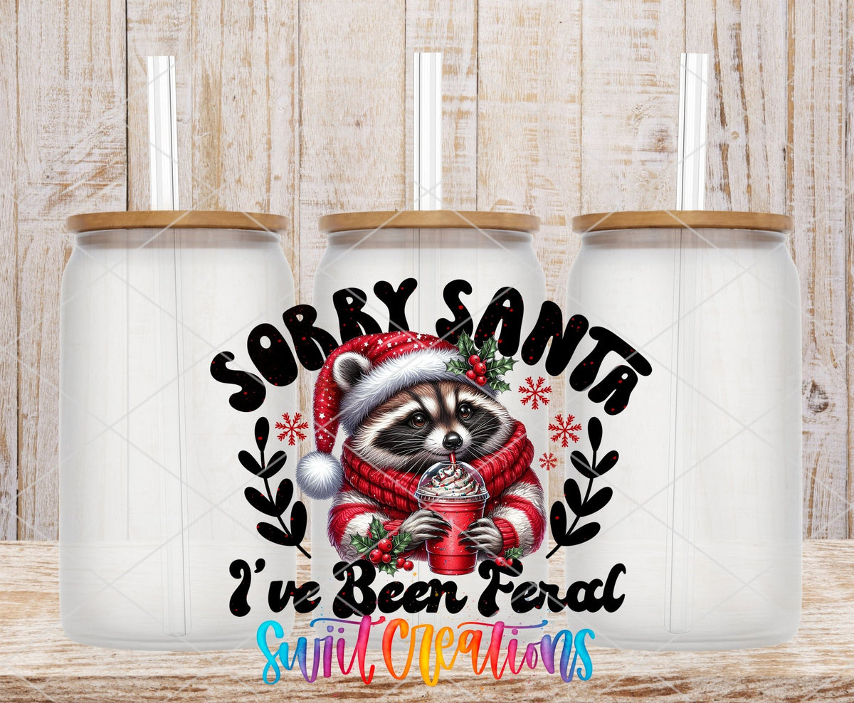 Swiit Creations UV DTF Feral Raccoon Christmas transfer shown on a clear glass can set