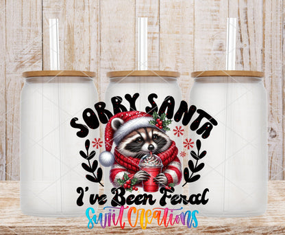 Swiit Creations UV DTF Feral Raccoon Christmas transfer shown on a clear glass can set
