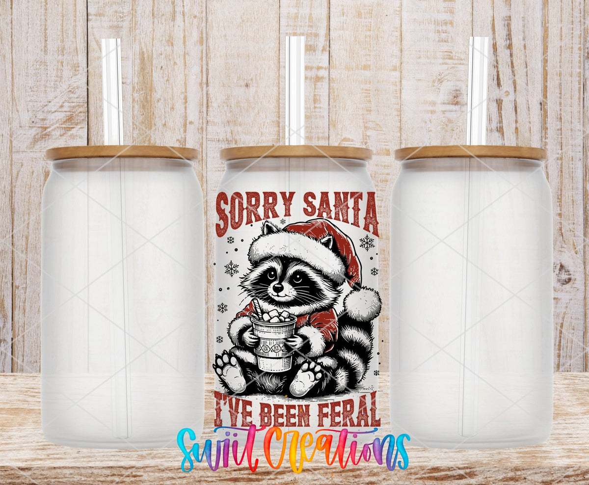 Swiit Creations UV DTF Feral Raccoon Christmas transfer shown on a clear glass can set